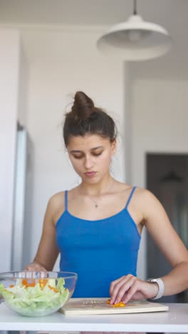 mujer preparando una ensalada en la cocina