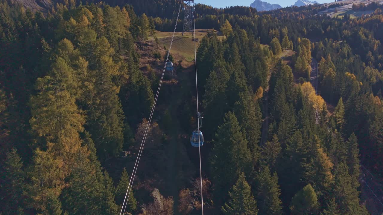 Corsa in funivia di montagna sotto un cielo azzurro e limpido, prospettiva drone