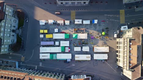 birdview droneshot of the federalplace in bern in front of the "bundeshaus" where a market is happening during carneval
