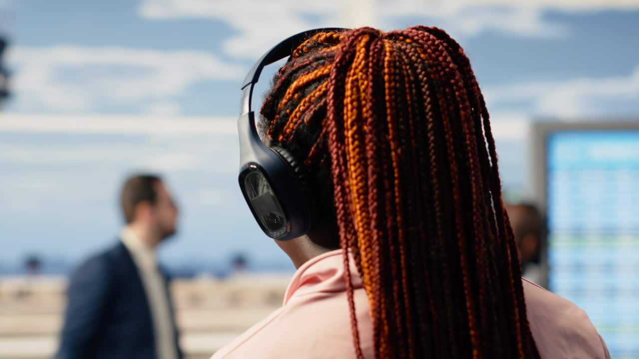 Ragazza afroamericana che ascolta musica e aspetta l'imbarco sull'aereo.