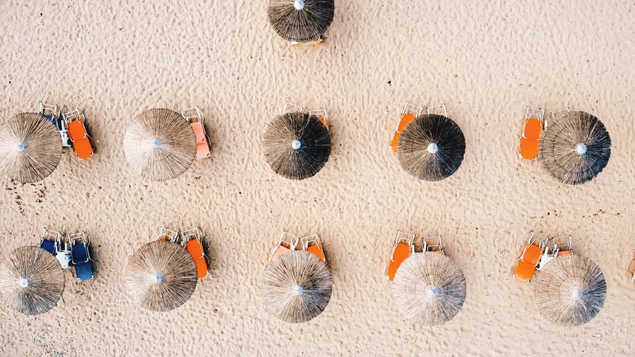 Beach with umbrellas and sunbeds. Foam. Top drone view