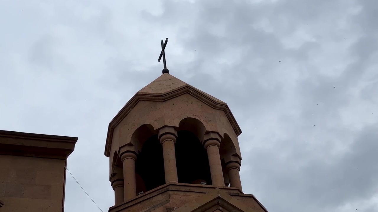 Cielo nuvoloso e coperto sullo sfondo in un paesaggio rurale isolato in cima a una collina, di un monumento di chiesa storica medievale ortodossa cattolica con architettura della facciata in pietra di tufo vulcanico, Yerevan, Tbilisi, Georgia, Iran.