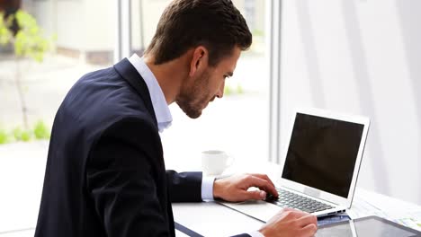 Businessman-working-on-laptop-at-desk-4k