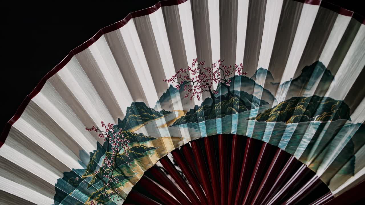 Close-up of a traditional fan with landscape art, captured from a low angle