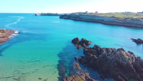 Perfect-for-diving-transparent-blue-water-sandy-beach-in-Spain,-with-cliffs-and-a-great-sky