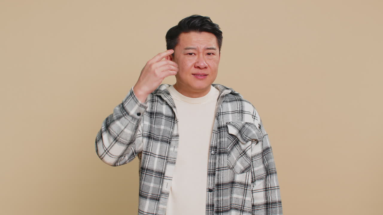Confused asian man pointing at camera showing stupid asking for insane crazy bad plan bullying