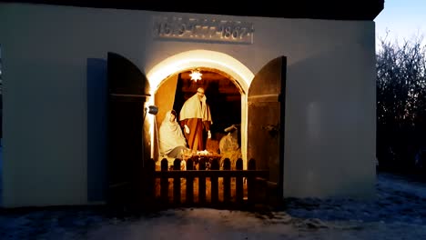 the birth of jesus christ illustrated, storytelling scene with crib in the stable on public display, christmas time