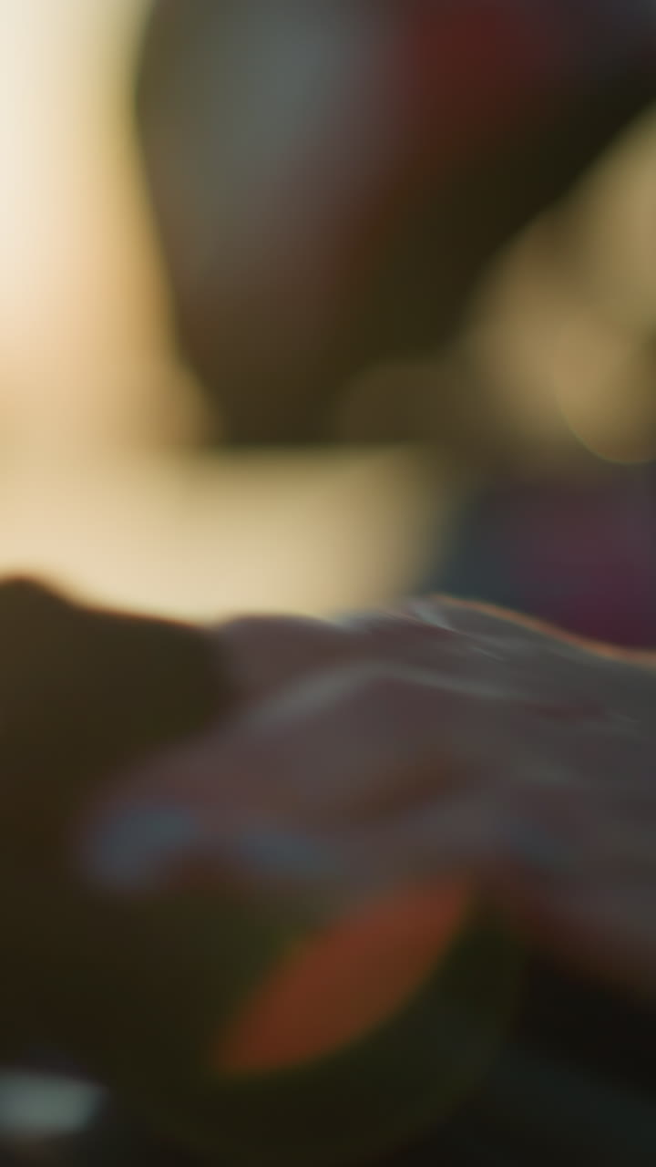 un primer plano de la mano de una persona que lleva una pulsera verde, limpiando o limpiando suavemente el asiento trasero de una motocicleta