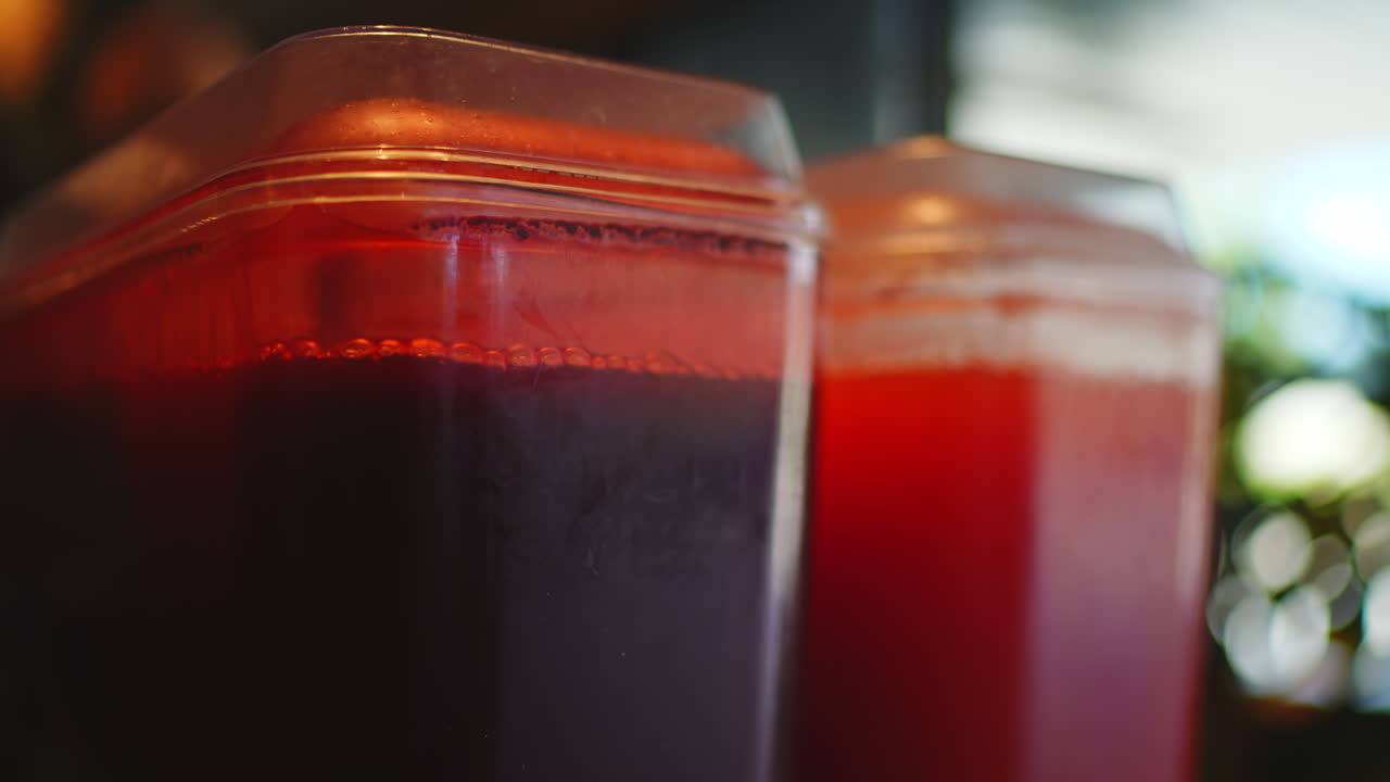 Primo Piano di Succhi Rossi e Rosso Scuro in Contenitori di Plastica