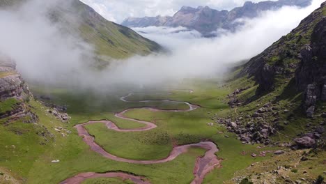 Aguas-Tuertas-Valley,-Spanish-Pyrenees,-Spain---Aerial-Drone-View-of-the-Green-Valley,-Curved-River,-Mountains-and-Moving-Clouds