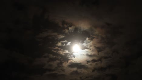 el lapso de tiempo de la luna moviéndose detrás de nubes cambiantes