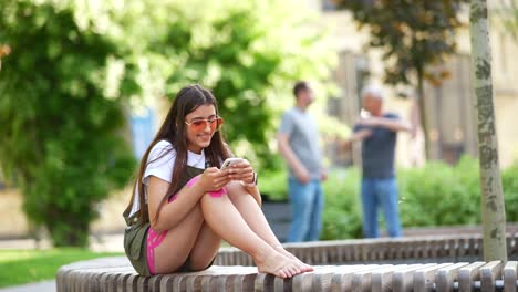 adolescente usando su teléfono inteligente en un parque