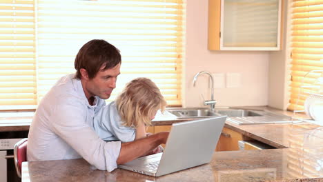 father and son using a laptop together