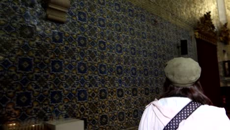 Woman-enters-Aveiro's-Igreja-da-Misericordia,-adorned-with-blue-tiles,-and-expresses-surprise