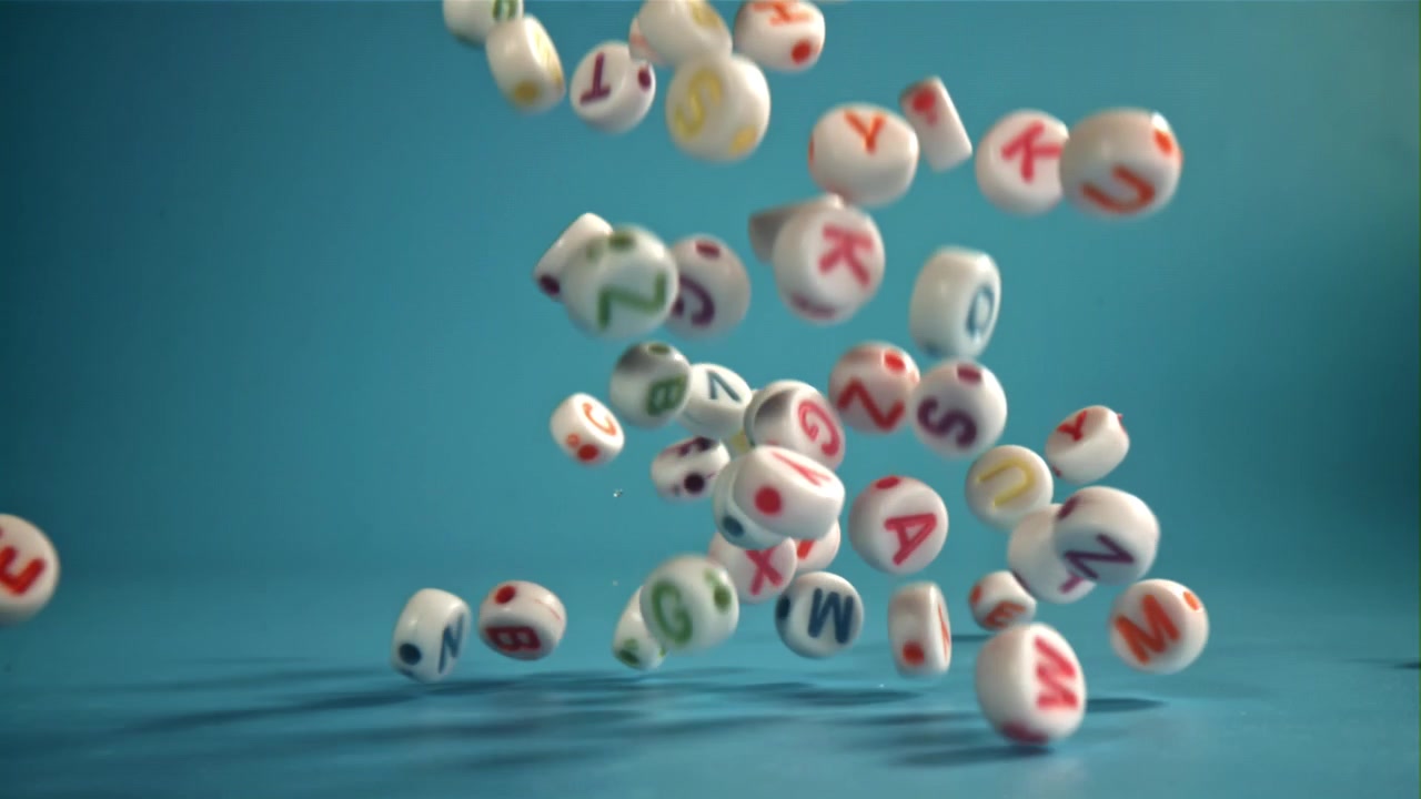 Colorful Alphabet Letter Beads Falling and Bouncing on a Blue Background