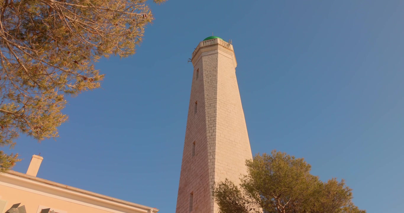 Alta torre faro sulla costa contro il cielo blu, Francia.