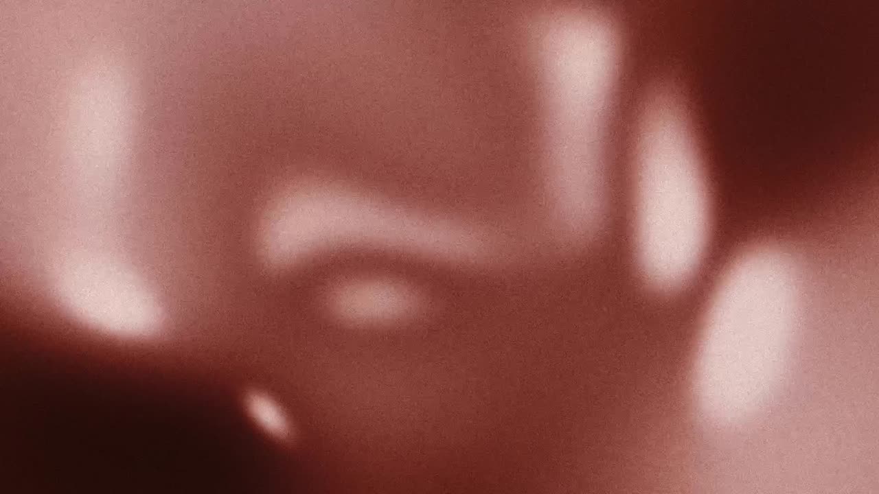 Forme astratte e sfocate di luce in movimento su sfondo rosso granuloso