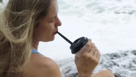 woman enjoying coffee at the beach