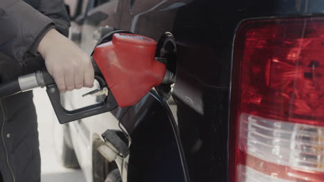 the owner of the car fills gasoline in the tank