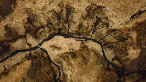 aerial top view of a stream of water flowing in a gorge in iceland, during winter time