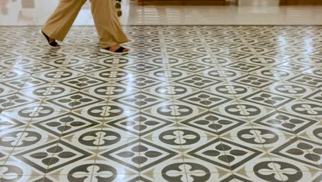 feet moving across patterned tiles in bangkok