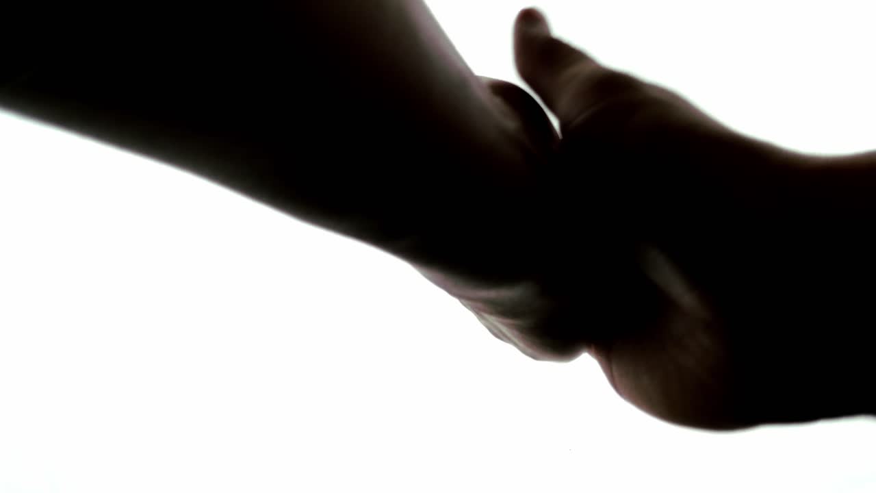 mirando a lo largo del brazo de una persona anónima para verlos aplaudiendo suavemente