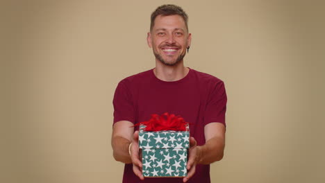 hombre guapo presentando caja de regalos de cumpleaños, oferta envuelta regalo bonificación de carrera, fiesta de celebración