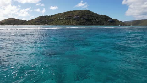 panoramic aerial view of british virgin islands coastline from caribbean sea, flying above coral reefs, drone shot