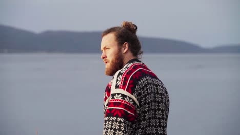 rear of a man walking towards the lake and removed his sweatshirt