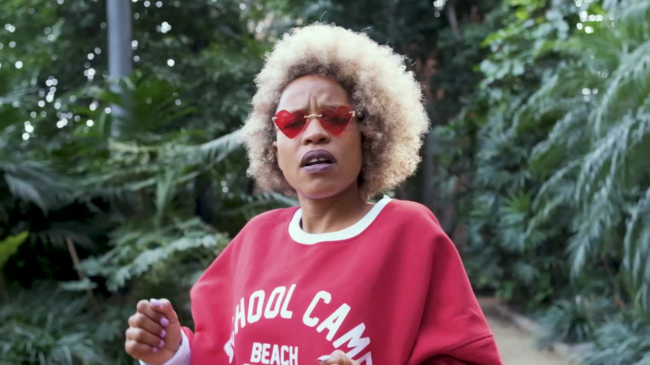 Woman with Blonde Afro and Heart Sunglasses