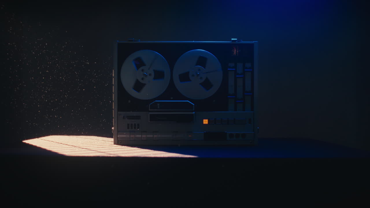 A vintage tape recorder spinning spools in a blue light