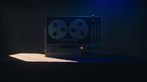 a vintage tape recorder spinning spools in a blue light