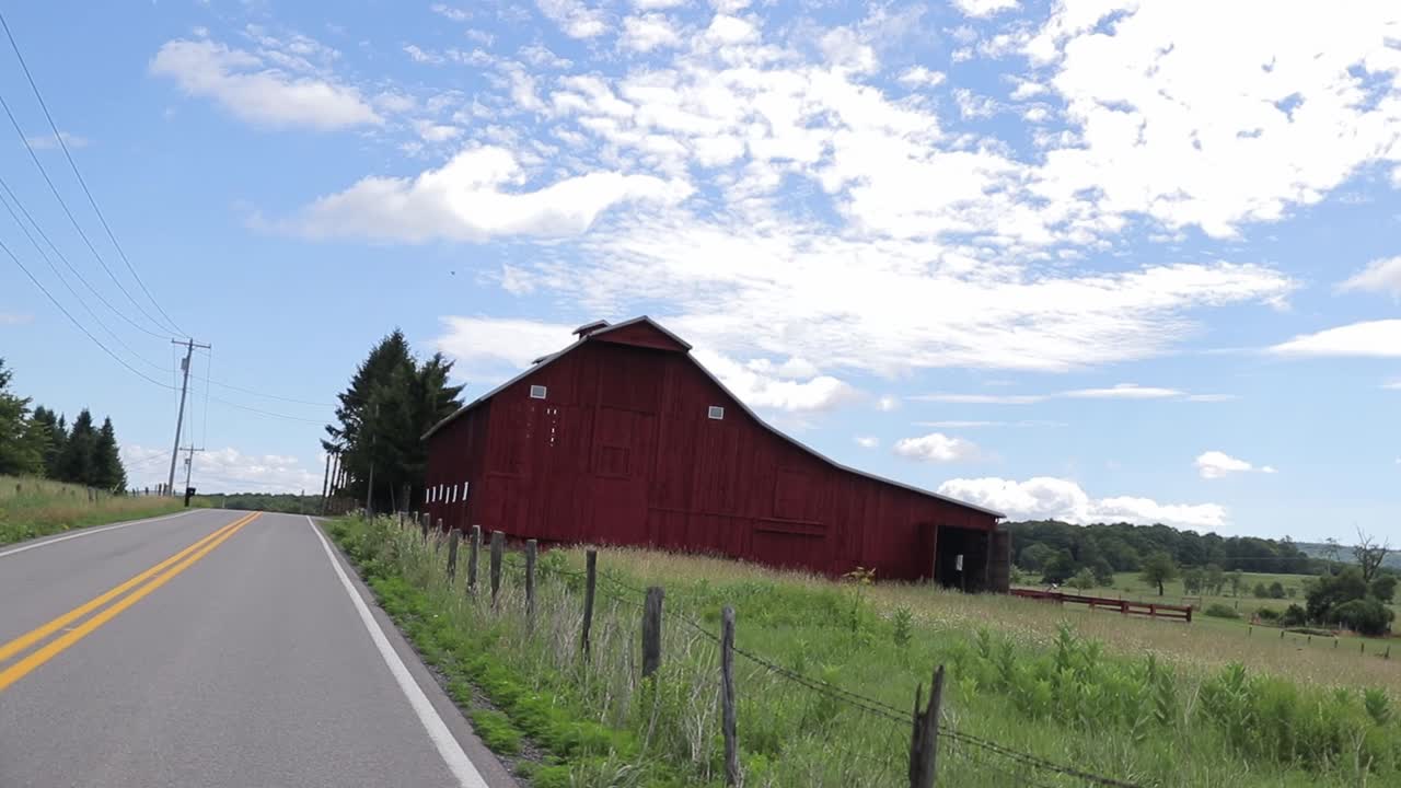 Red Barn Dolly Zoom Shot Vertigo Effect Driving Toward Barn On Farm With Clouds In Blue Sky