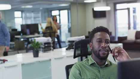 Thoughtful-man-sitting-on-his-desk-at-office-