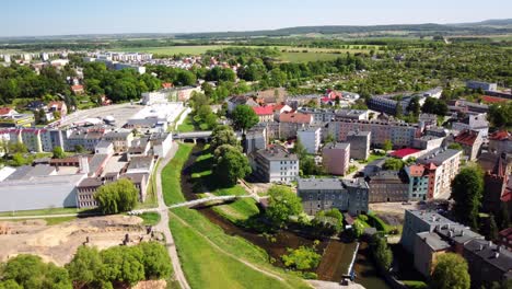 la ciudad de prudnik con su pintoresco río, edificios históricos y un vasto campo en el fondo