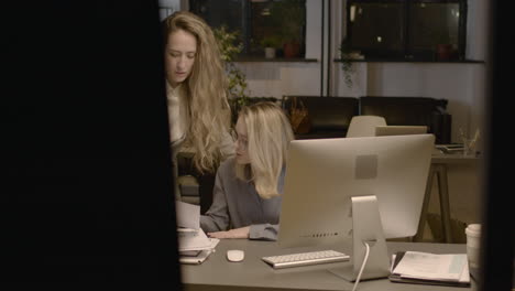 Two-Female-Employees-Talking-Together-And-Checking-Reports-In-The-Office