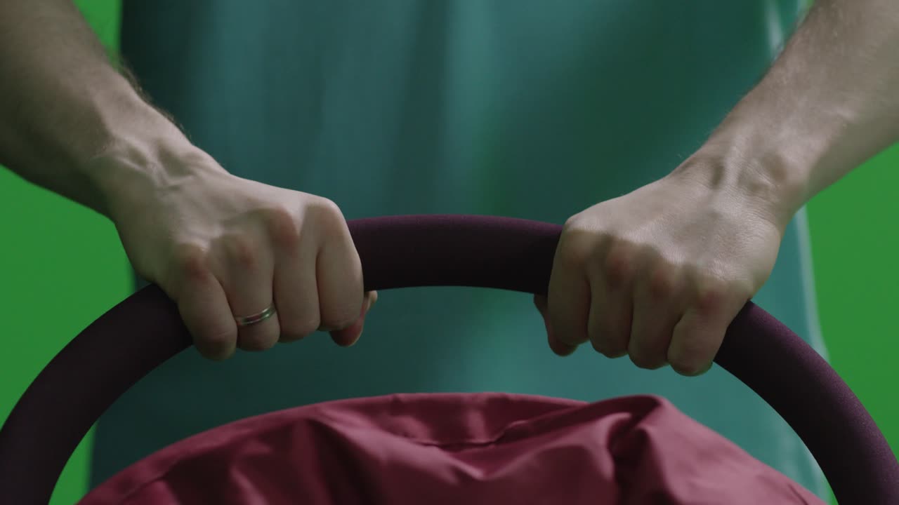 초록색 스크린에서 아기 보행차를 밀고 있는 사람