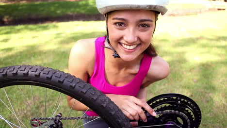 fit girl fixing the chain on her bike