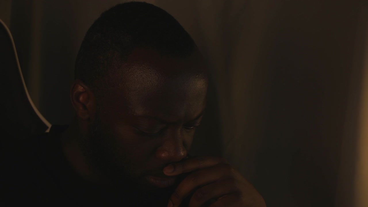 hombre negro pensando intensamente por sí mismo en la habitación