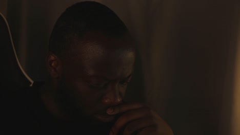 black male thinking intensely by himself in room