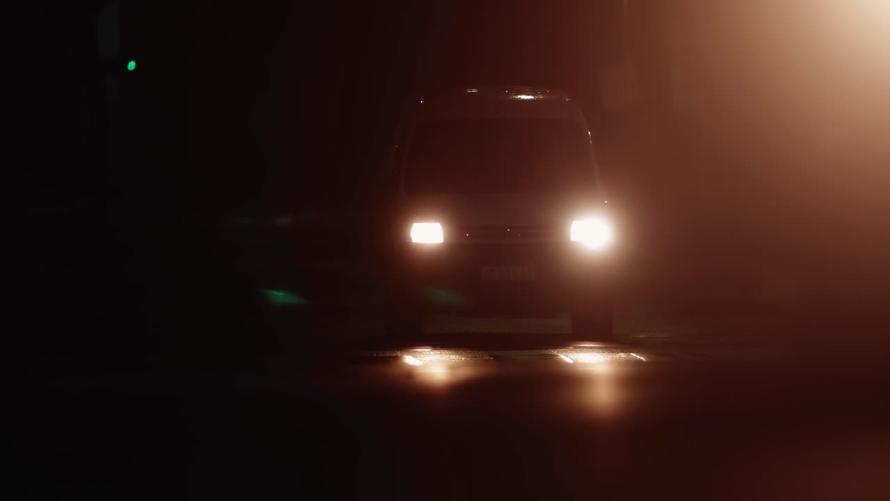 Car Headlights Approaching and Passing on a Dark Night Street