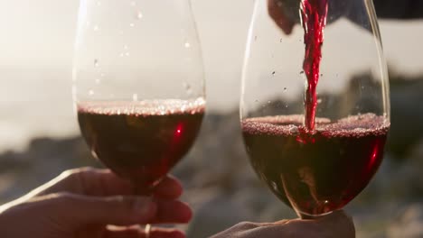 Man-pouring-wine-by-the-sea