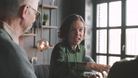 happy woman talking to her family while sitting at table and having a meal together at home