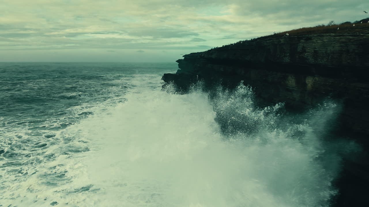 Powerful Ocean Waves Crashing Against a Rugged Coastal Cliff
