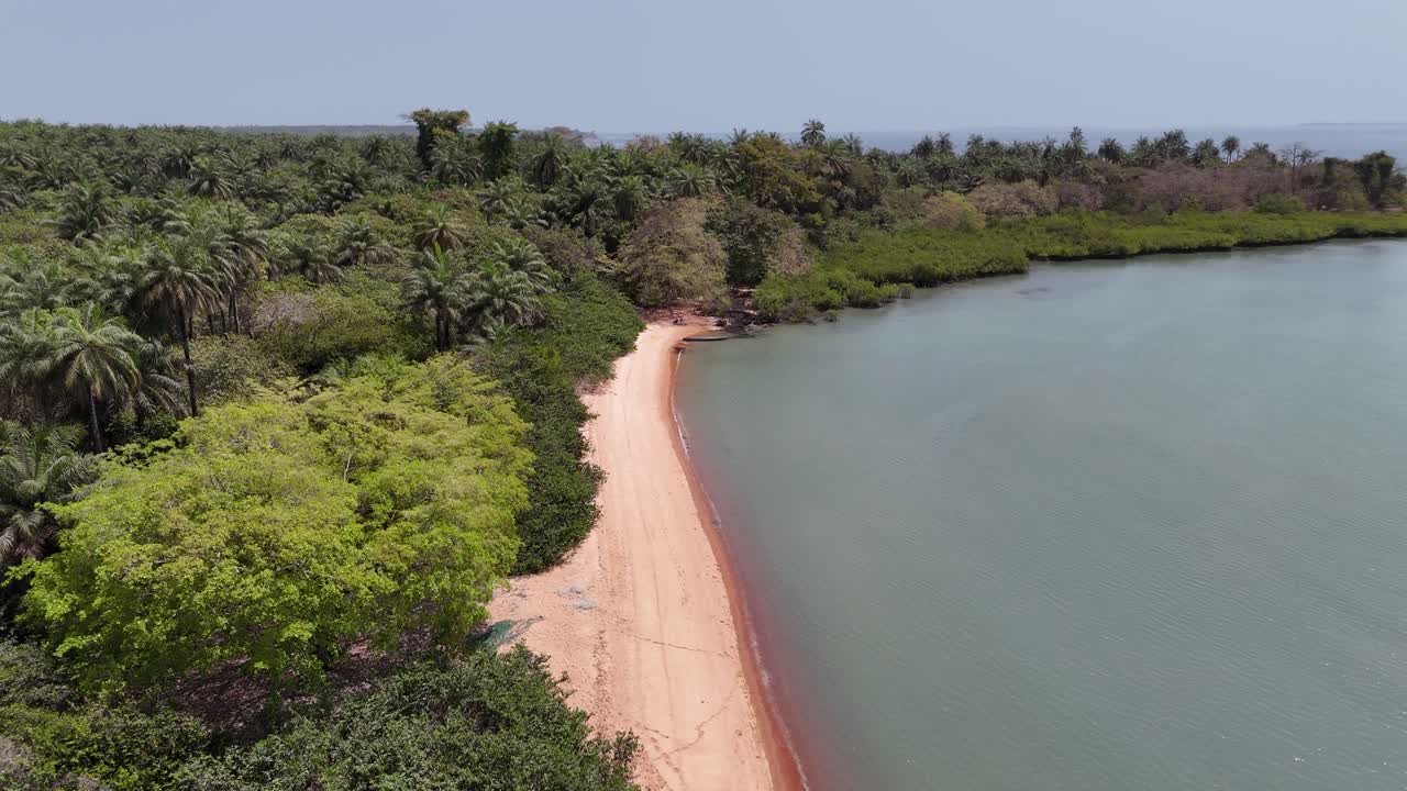 Aerial panorama of Pink Sand Beach in Guinea-Bissau, highlighting the contrast of pink sands, lush greenery and turquoise Atlantic waters