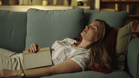 woman sleeping on couch with book