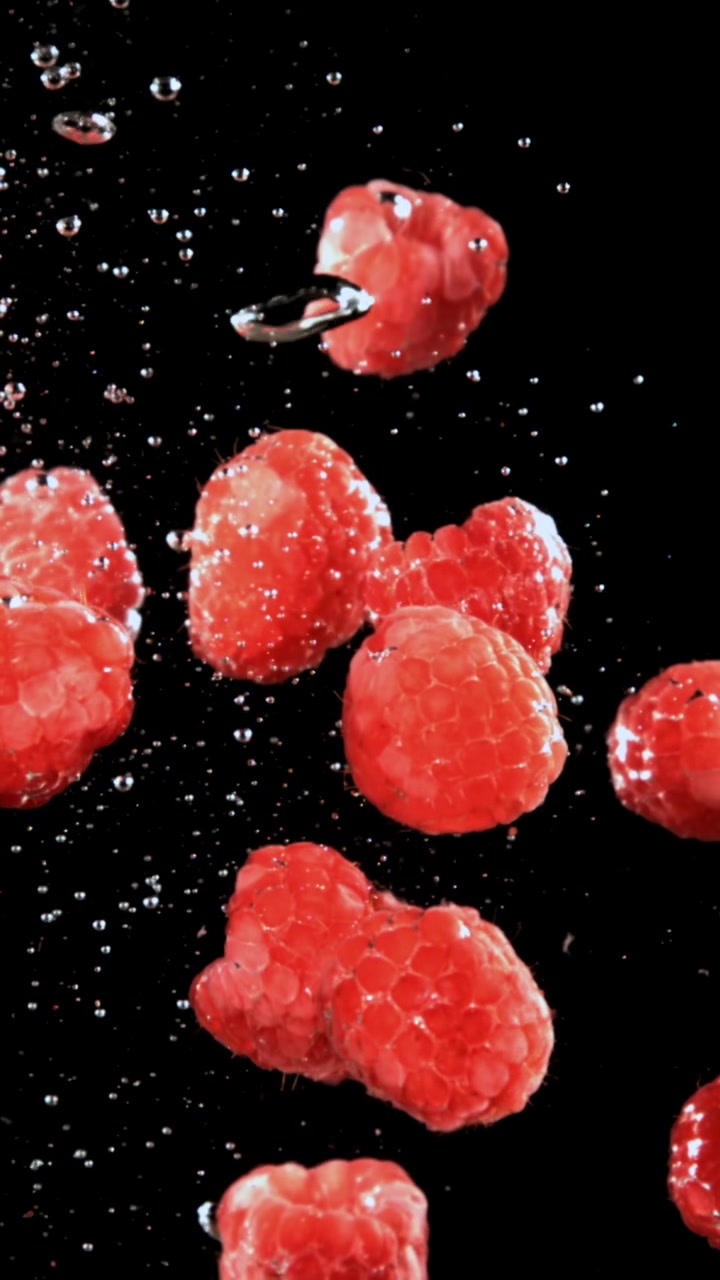 Fresh Red Raspberries Floating in Water with Bubbles