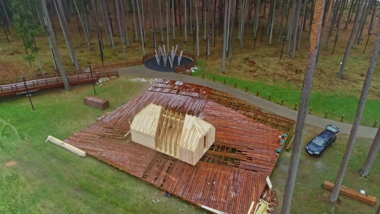 Drone flight from a platform with a timber frame of a house under construction.