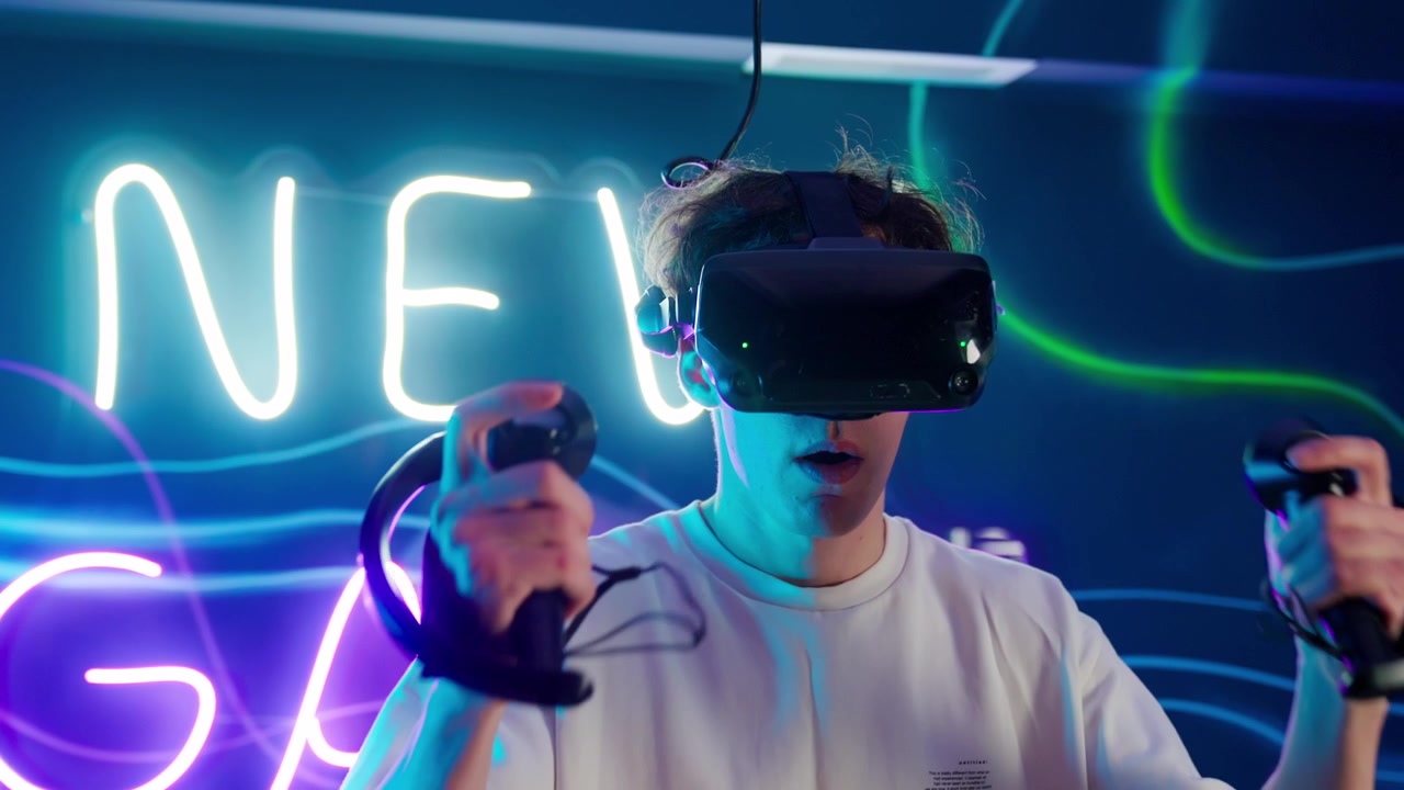 Giovane uomo che gioca a un gioco di realtà virtuale in una stanza illuminata al neon