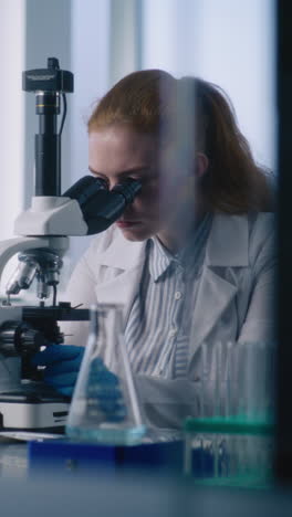 female scientist working with microscope in a lab